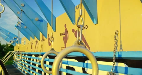 Close up front view of gymnastic rings exercise bars swinging in a fitness area Stock Footage 202276393