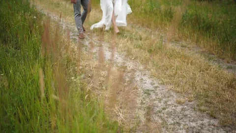 Close-up. Front view. Legs. The bride and groom are walking on the field. Stock Footage 129114562