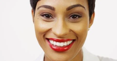Close up front view of pretty black woman with red lipstick smiling Foto stock