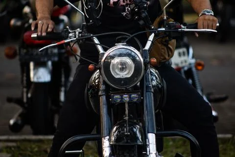 Close Up Front View of Rider Hands on Handlebars of Classic Black Motorcycle Stockfoto's