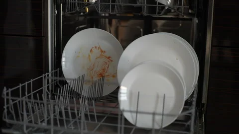 Close-up front view of unrecognizable man loading dishwasher with dirty plates Stock Footage 241332032