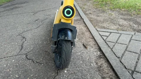 Close-up of the front wheel and headlight of a yellow electric scooter Stock Footage 340997598
