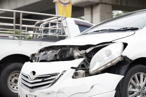 Close-up of front of white car get damaged by accident on the road. concept o Stock Photos