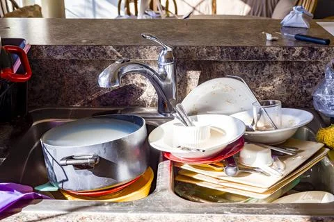 Close up frontal view of a kitchen mess with dirty pots, dishes and utensils  Stock Photos