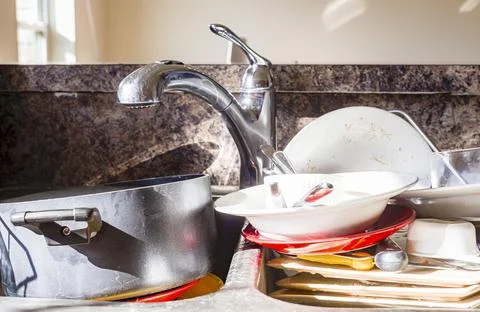 Close up frontal view of a kitchen mess with dirty pots, dishes and utensils  Stock Photos