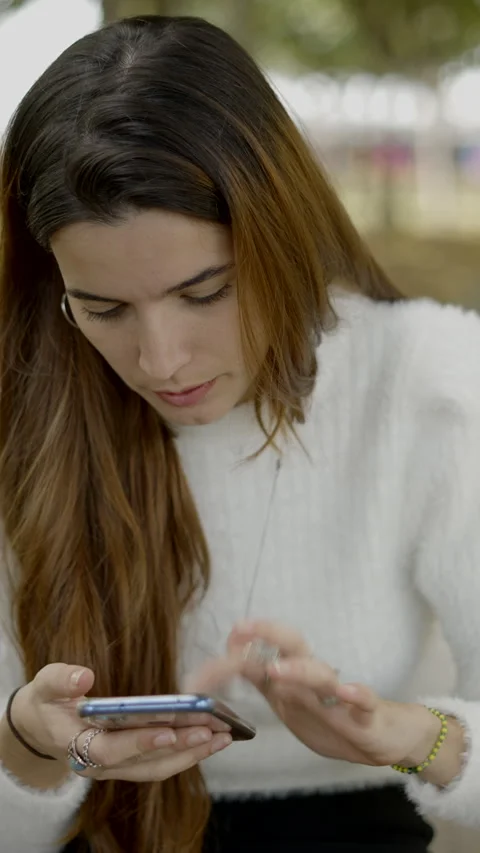 Close frontal view of stressed young woman scrolling on her phone Vídeo Stock 265955290