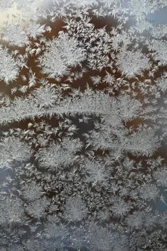 Close-up of Frost Patterns on a Window with Natural Light Background Stock Photos