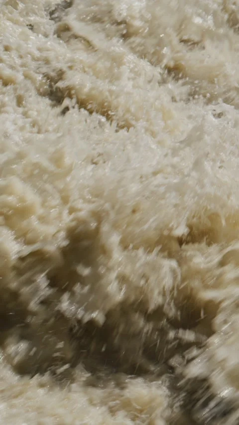 Close-up of frothy, muddy water in fast-moving river or flood Stock Footage 335570389