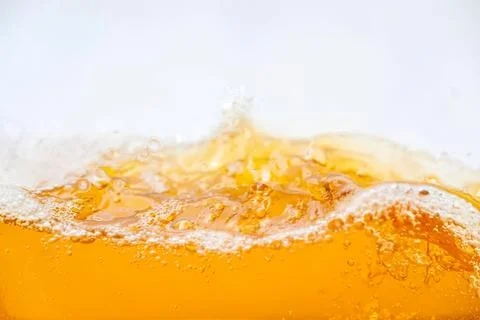 Close-up of frothy orange soda with bubbles and splash Foto stock