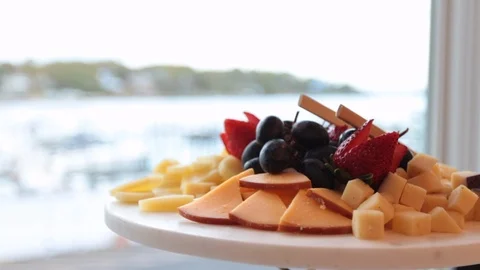 Close up of fruit and cheese plate with large bright window Stock Footage 107945141