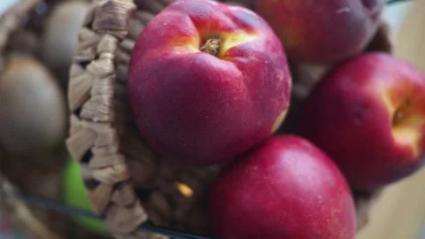 Close up fruit basket with nectarines and kiwi in natural light. Stockbeeldmateriaal 331927494