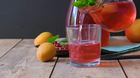 Close-up of fruit compote is poured into a glass cup, a refreshing drink. Stock Footage 279972501