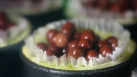 Close up of fruit tartlet dessert being prepared with glossy chocolate pearls or 動画素材 343018240