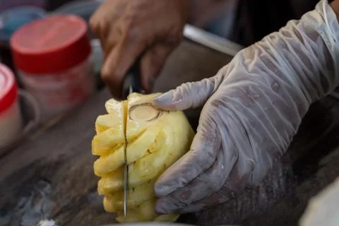 Close up Fruit traders are cutting pineapple for sale. Street Food in Thailan Stock Photos