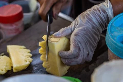 Close up Fruit traders are cutting pineapple for sale. Street Food in Thailan Stock Photos