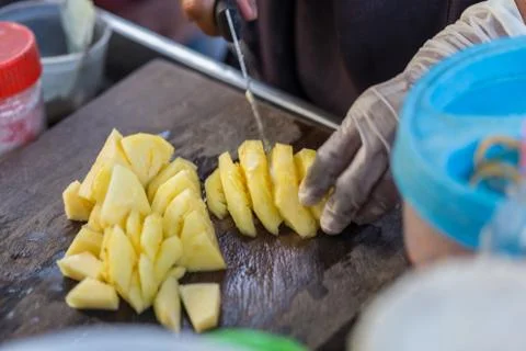 Close up Fruit traders are cutting pineapple for sale. Street Food in Thailan Stock Photos