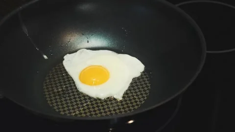 Close-up of frying egg cooking on non-stick pan indoors at nighttime Stock Footage 340879895