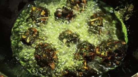 Close-up frying of lentil, moong pulse, onion, green leaves fritters video. 4k. Stock Footage 277252688