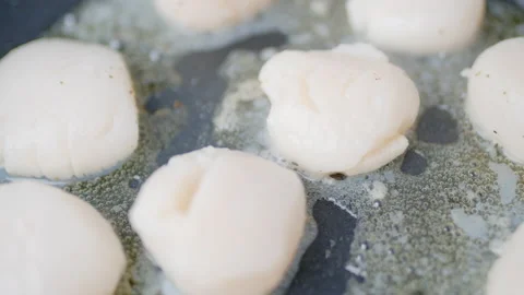 Close-up of frying lots, multiple scallops in oil in a pan on a gas stove in 4K. Stock Footage 138060208