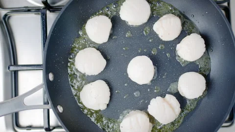 Close-up of frying lots, multiple scallops in oil in a pan on a gas stove in 4K. Stock Footage 138061973