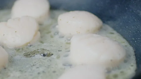 Close-up of frying lots, multiple scallops in oil in a pan on a gas stove in 4K. Stock Footage 138062453