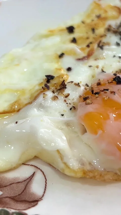 Close-up in a frying pan chicken egg is fried, oil splashes scrambled eggs Stock Footage 280113503
