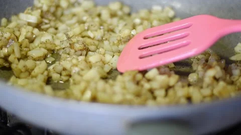 Close up frying potatoes in bowl while a hand beating it Stock Footage 238940018