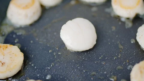 Close-up of frying raw scallops in the pan, turning on the other side in 4K. Stock Footage 138062840