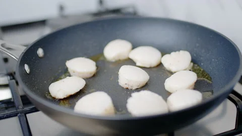 Close-up of frying raw scallops in the pan, turning on the other side in 4K. Stock Footage 138065456