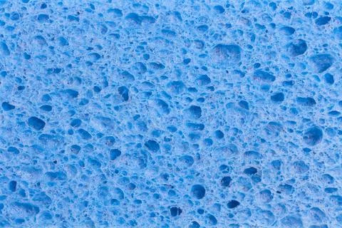 Close up full frame of a blue cleaning sponge with a pitted porous surface,.. Stock Photos