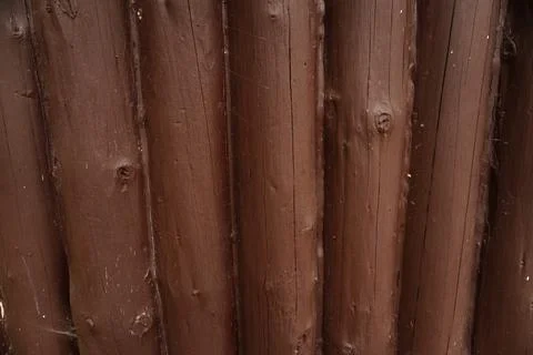 Close-up full-frame view of a dark brown painted wooden log wall or fence Стоковые фото