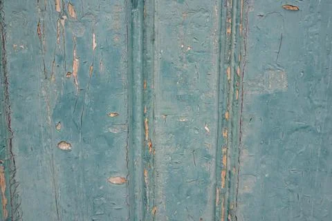 Close-up full frame view of peeling teal paint on weathered wooden panels Фото