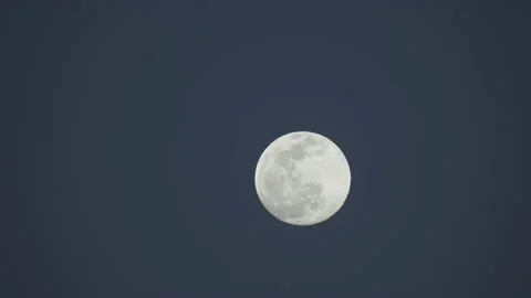 Close-up of a full moon against a clear sky with few clouds 4K video Video stock 147684316