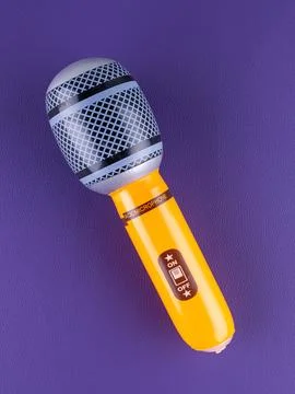 Close-up of a fun orange  inflatable microphone toy for entertainment on a pu Stock Photos