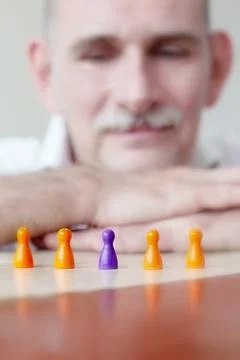Close-up of game pieces on table and businessman Stock Photos