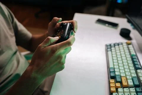 Close-up of gamer hands holding using black wireless game controller, focused on Stock Photos