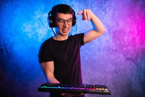 Close-up on gamer's hands going to press a key on a keyboard. Background is lit Foto stock