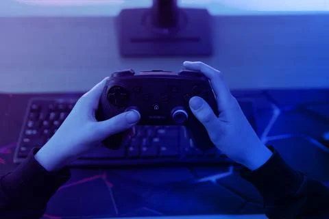 Close up of gaming controller in hands with blurred racing video game on mo.. Stock Photos