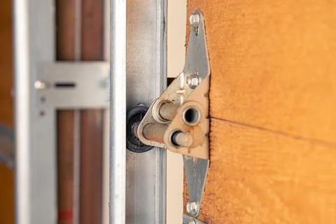 Close up of garage door hinge and roller on wooden door, selective focus. Stock Photos