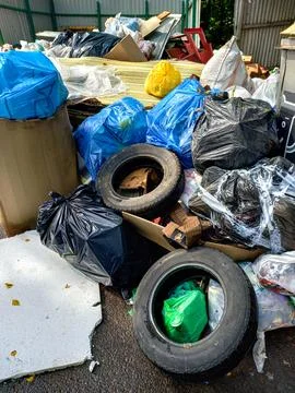 Close-up of garbage dump with bags, boxes, tires. Pollution of environment... Stock Photos