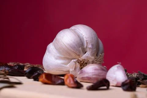Close up on Garlic cloves on rustic table mixed with fresh spices and herbs.  Stock Photos
