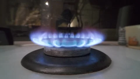Close-up of a gas burner with a steady blue flame. Modern kitchen stove. Stock Footage 327649770