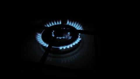 Close-up of a gas stove burner igniting with blue flame Stock Footage 300882802
