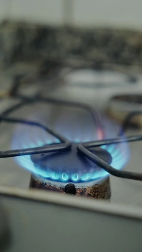Close up of a Gas Stove Burner Igniting with a Blue Flame Stock Footage 336001686