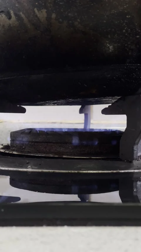 Close-up of gas stove burner igniting with blue flame Stock Footage 343331400
