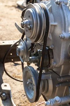 A close-up of a gasoline engine with multiple pulleys and a drive belt, illus Stock Photos