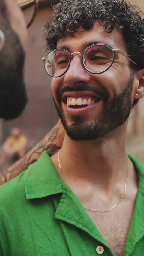 Close-up of gay couple laughing while standing on street of old city Stock Footage 257316382