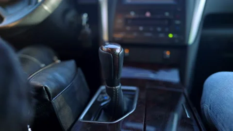 Close-up of gear shift with unrecognizable Caucasian woman turning steering Stock Footage 148757675