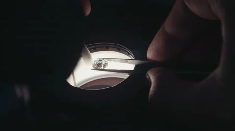 Close up of a gemologist inspecting a diamond with a microscope Stock Footage 65258104