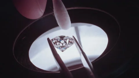 Close up of a gemologist inspecting a large diamond under a microscope Stock Footage 65258273